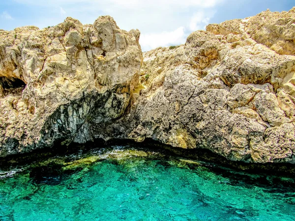 En stor vit klippa i havet mot en bakgrund av blått vatten — Stockfoto