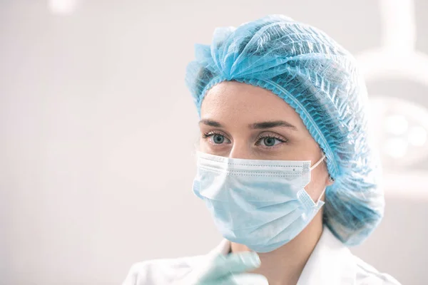 Молода біла жінка в стоматології з маскою на обличчі — стокове фото