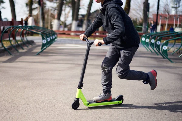 Kid riding on stunt scooter in the skatepark