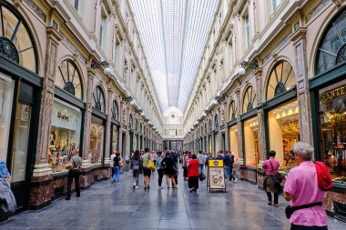 Galeries Royales Saint-Hubert gün batımında sıcak ışıklar parlayan