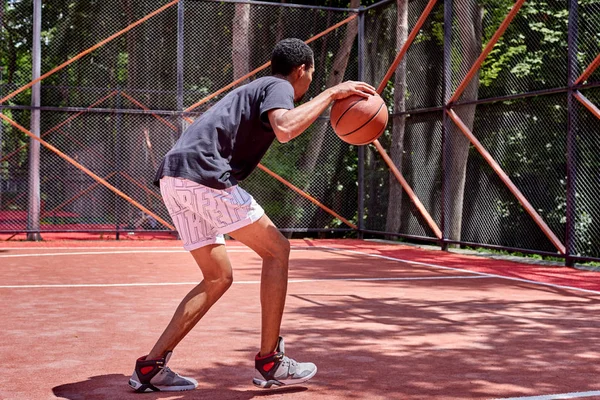 Чёрный баскетболист, играющий на поле — стоковое фото