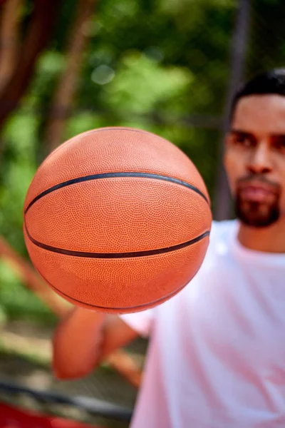 Черный баскетболист держит мяч в руках — стоковое фото