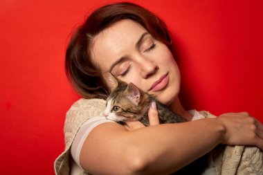 Kadın küçük bir kedi ile oynuyor