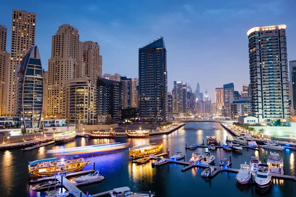 Dubai marina with boats and buildings with gates at night with l — Stock Photo, Image
