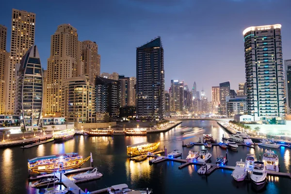 Dubai marina with boats and buildings with gates at night with l — Stock Photo, Image