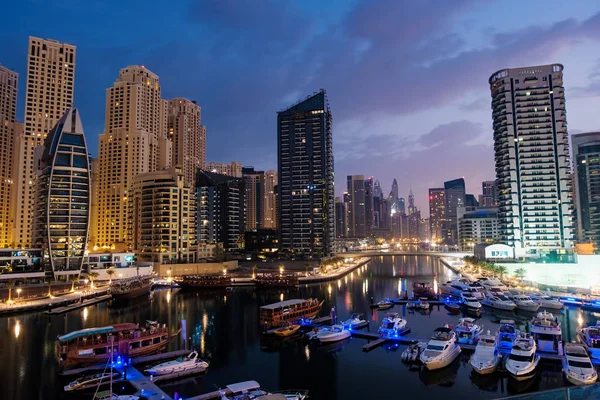 Dubai marina con barcos y edificios con puertas en la noche con l — Foto de Stock