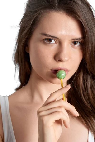 Young girl sucking lollipop and looking at the camera — Stock Photo, Image