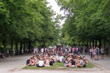 Büyük insan grupları parkta dinleniyor.