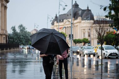 Calea zafer meydanında yağmurda siyah şemsiyeli insanlar