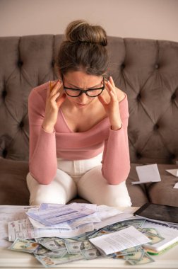 Stresli kadın evde para sayıyor. Yatırım fırsatları, maaş bordroları, fatura bütçesi