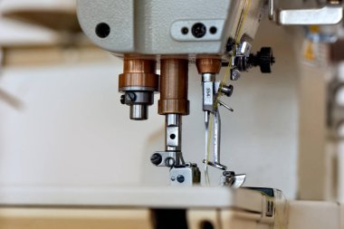 Tekstil üretiminde kumaşla çalışmak için dikiş makinesi