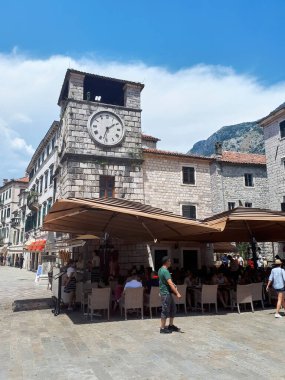 KOTOR, MONTENEGRO - 5 Temmuz 2019 Dinlenen insanlarla dolu bir meydanda kafe