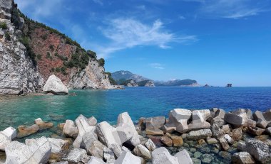 Adriyatik Denizi 'nin kayalık kıyıları, mavi sulara yakın uçurumlar ve Karadağ' ın Petrovac kentindeki yeşilliklerle kaplı tepeler