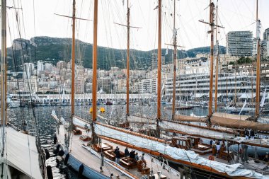 Monaco 'da demirlemiş eski gemiler, arka planda insanlar, yatlar ve binalar var.