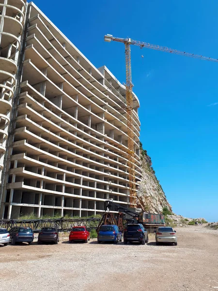 House construction with crane and parked cars in Petrovac, Montenegro