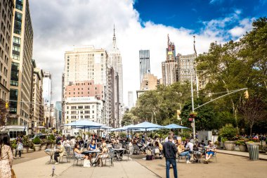 NEW YORK, ABD - 19 Eylül 2019: dinlenen birçok insan, yüksek binalar ve yeşillik ile sokak. Canlı renkler