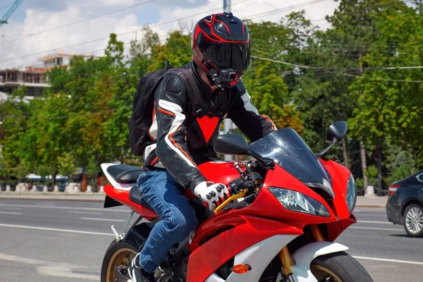 黒と赤のヘルメットと道路に乗って赤い自転車でバイカー チシナウの背景に公園 モルドバ — ストック写真