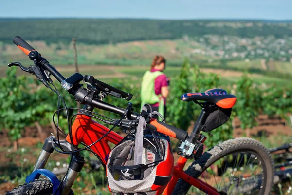 Parked bicycle on a country road with woman and greenery on the background