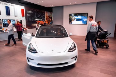 BOSTON, MASSACHUSETTS - 5 EKİM 2019: Beyaz Tesla araba galerisinin içinde ve içinde insanlar varken