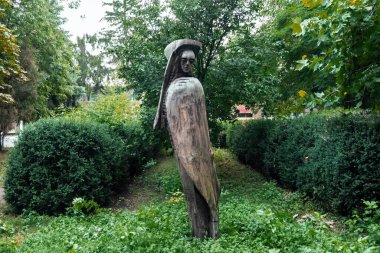 Moldova çevresindeki yemyeşil yemyeşil ağaç gövdesinden yapılmış bir insan heykeli.