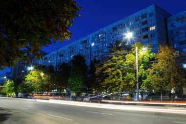 CHISINAU, MOLDOVA - 18 Ağustos 2020: Chisinau, yakındaki ağaçlarla yol, arka planda daireler, ışık izleri, Moldova