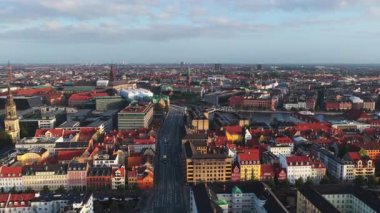 Kopenhag 'ın, Danimarka' nın tarihi kuleleri, modern binaları ve parlak bir sabah gökyüzü altında kırmızı çatıları olan insansız hava aracı görüntüsü.