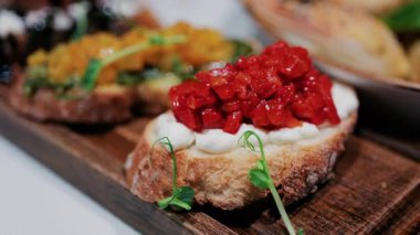 Krem peynirle kaplanmış kırsal bruschetta ve taze yeşilliklerle süslenmiş kavrulmuş kırmızı biber.