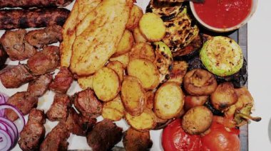Kızarmış patates, domates, mantar ve sosla servis edilen sulu ızgara et.