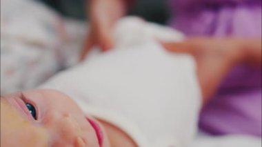 Bebeğiyle hareket egzersizi yapan bir annenin yakın çekimi.