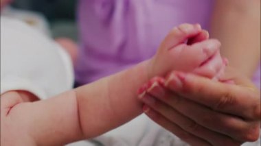 Bebeğin ellerine ve kollarına masaj yapan bir ebeveynin ellerini kapat.