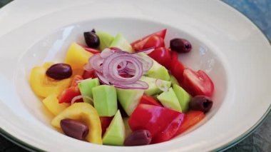 Salatalık, domates, dolma biber, kırmızı soğan halkası ve Kalamata zeytinli taze Yunan salatası.