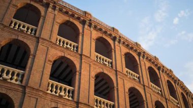 Valensiya, İspanya 'da tekrarlanan kemer ve taş balyaları olan bir tuğla cephesinin alçak açılı görüntüsü