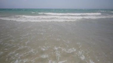 Güneşli bir günde rüzgarla sürüklenen parlak turkuaz deniz yüzeyi manzarası