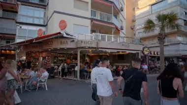 Benidorm, İspanya - 25 Mayıs 2025: Akşamları hareketli mobiletler ve plaj giyim mağazalarıyla dolu Levante gezinti alanı