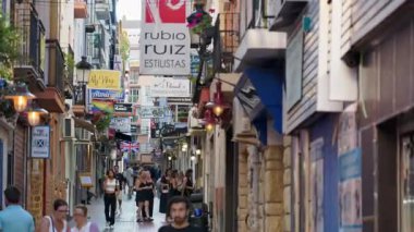 Benidorm, İspanya - 25 Mayıs 2025: daracık sokak, akşamları işaretler, bayraklar ve yoğun barlarla dolu