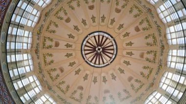 Upward tilt to the painted central dome and skylight, with floral motifs and radial beams at the Central Market of Valencia, Spain