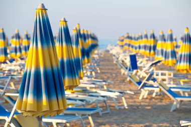 Mavi ve sarı şemsiye güneşli bir plaj. Ünlü Rimini plaj arka plan.