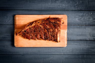 Siyah ahşap zemin üzerine kesme tahtası üzerinde kaburga füme. Tema lezzetli yemekler.