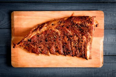 Ahşap arka plan siyah yakın çekim üzerinde füme lezzetli kaburga. Baharatlı domuz kaburga.