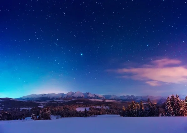 Muhteşem gece manzarası. Mavi gökyüzü parlak yıldızlarla dolu. Kış dusk dağlar içinde.