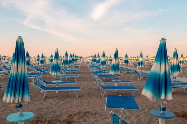 海滩为放松与太阳伞和椅子休息室在多彩的天空背景 — 图库照片