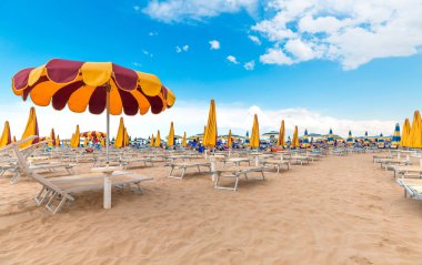 Rimini, İtalya - 12 Haziran 2018: Tropikal plaj beyaz kum ile. Rimini, İtalya. Açık mavi gökyüzü arka plan rengi şemsiyesi.