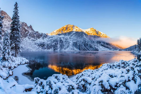 Mountains in winter. Summit illuminated with sunshine. Stunning winter mountain landscape with clear lake and blue sky. Winter background. Zakopane, Poland.