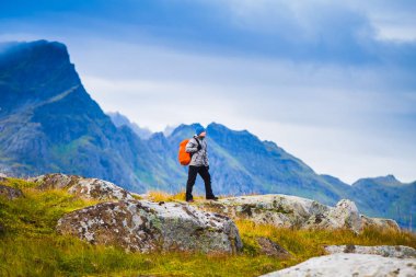 Norveç'te hiking. Fiyatı Dağları arka plan üzerinde kırmızı sırt çantası duran ile. İnsanlar ve doğa kavramı.
