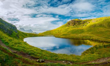 Bahar manzara. Norveç dağlar göl. Bahar doğa. Yeşil tepelerin üstündeki mavi gökyüzü.
