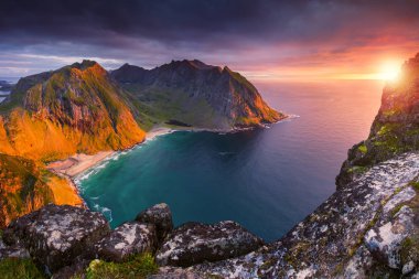 Lofoten Adaları deniz manzarası. Norveç. Bahar günbatımı. Fiyort güneş tarafından aydınlatılmış taşlarla.
