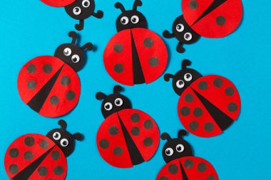 Sayma çalışmaya çocuklar için bir oyun. El yapımı kağıt ladybugs sırtında puana sahip farklı. Mavi bir arka plan üzerinde oyuncak ladybugs.