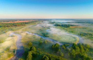 Bahar ya da yaz manzara. Bahar çayır altında açık mavi gökyüzü. Görünümünün üst hava. Misty dawn. Sabah sahne.