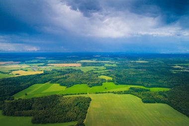 Bahar hava manzara. Belarus. Yeşil alanlar daha önce yağmur güneş ışığı ile. Yeşil çayırlar ve ormanlar üzerinde mavi bulutlar.