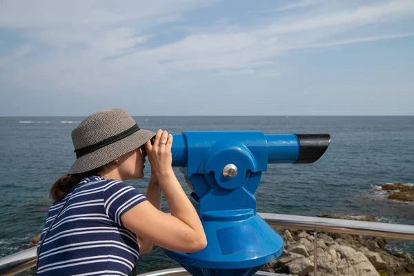 Mujer joven mirando en telescopio azul — Foto de Stock